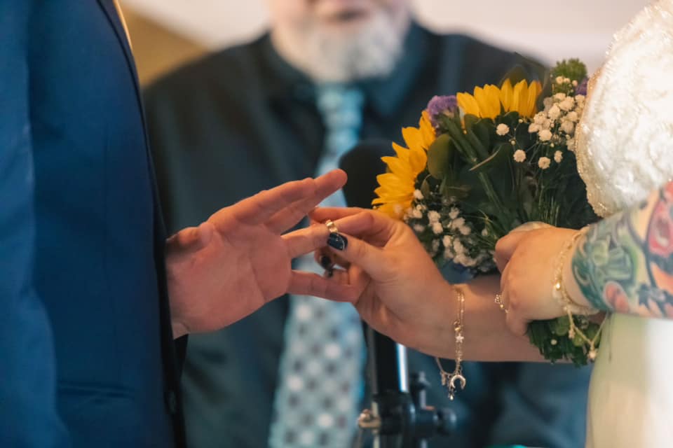 A closeup photo of Catherine putting a ring on Sean's hand