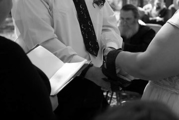 Paul and his wife Athena hold hands during their handfasting ceremony portion of their wedding